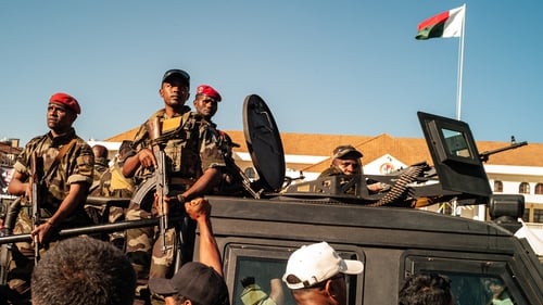 Crowds of people gather to demonstrate after soldiers entered the Presidential Palace