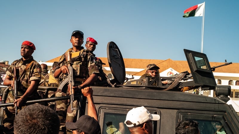 Crowds of people gather to demonstrate after soldiers entered the Presidential Palace