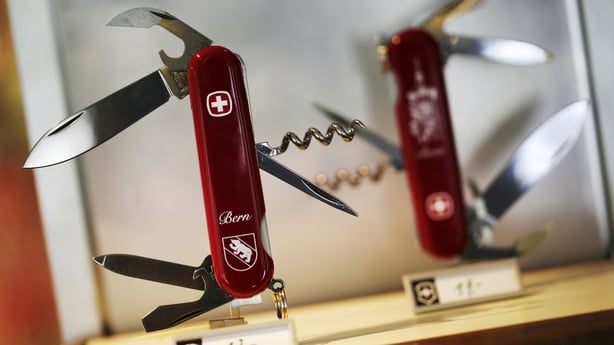 Image of two red Swiss army knives on a shop display