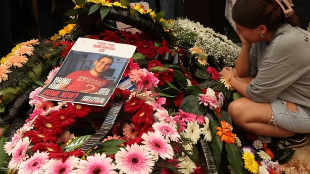 flowers and a photgraph are seen during a funeral in israel
