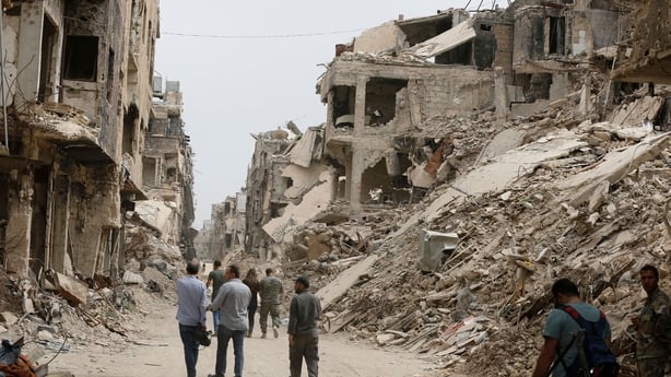 Members of the Syrian pro-government forces inspect the damage of a street in the Yarmuk Palestinian refugee camp on the southern outskirts of the capital Damascus on May 22, 2018. The government seized earlier in the week the Yarmuk Palestinian camp and adjacent neighbourhoods of Tadamun and Hajar