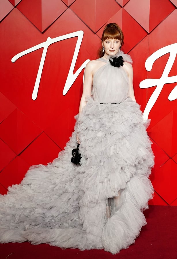 Nicola Roberts wearing a white ruffled dress on a red carpet