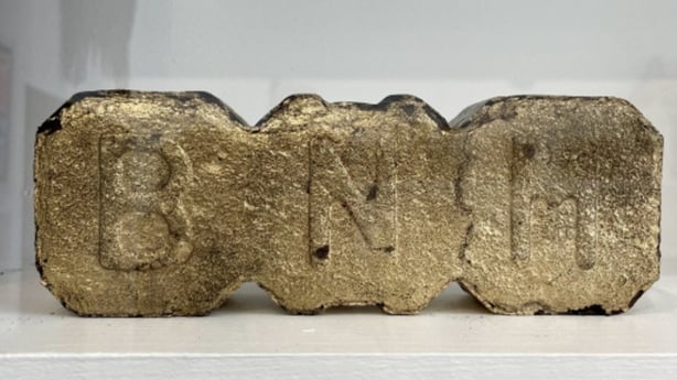 BNM peat briquette sprayed gold, in the 'Museum of Broken Things' – Cavan County Museum, photographed by Marion McGarry 2025