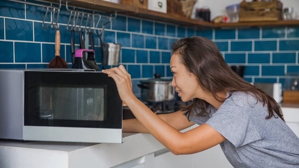 woman opening her microwave
