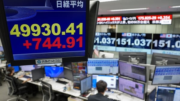 Screens display the Nikkei 225 value and the yen rate against the dollar in a Japanese trading room