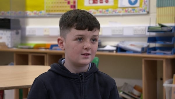A young boy being interviewed by news2day in a classroom wearing a navy hoodie