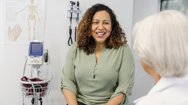 An unrecognizable senior adult female doctor listens attentively to the mid adult woman.