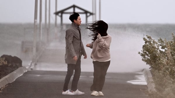 People stand near a jetty amid a stormy weather in Melbourne