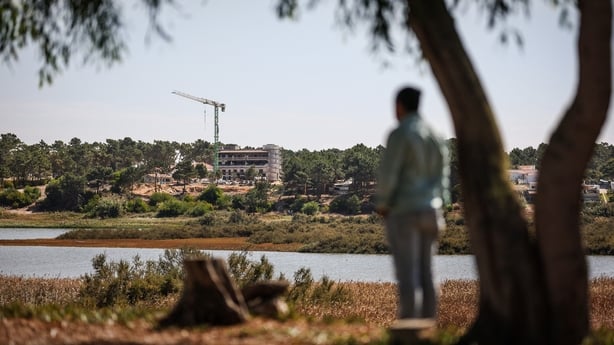 A construction crane stands over the building site of a new hotel