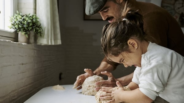 father and child baking bread at home
