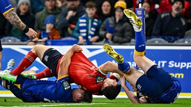 18 October 2025; Tom Farrell of Munster is tackled by Scott Penny, left, and Ciarán Frawley of Leinster which resulted in a penalty try during the United Rugby Championship match between Leinster and Munster at Croke Park in Dublin. Photo by Sam Barnes/Sportsfile