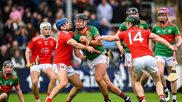 Evan Maxted of Clooney Quin (red and green) in action against Shane O'Donnell of Éire Óg Ennis - 2025 Clare hurling final