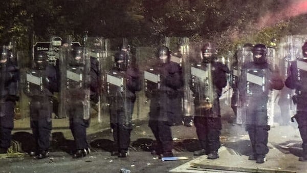 Row of gardaí holding plastic shields