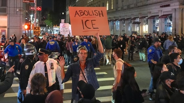 A man holds a flag reading 'abolish ICE' during a protest in new york city
