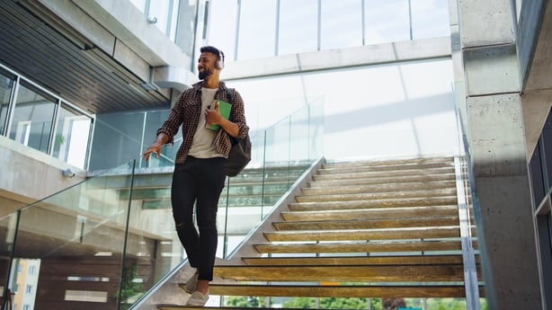 A cheerful man walking down the stairs.