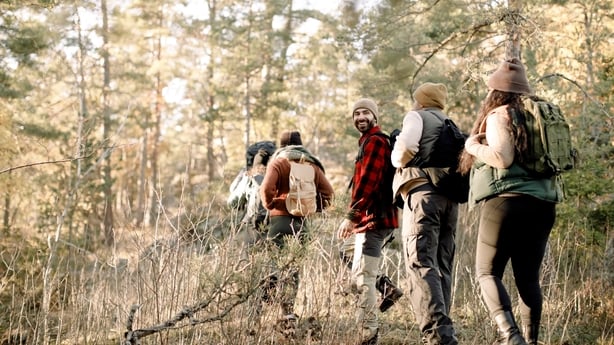 a group of people walking outside during autumn