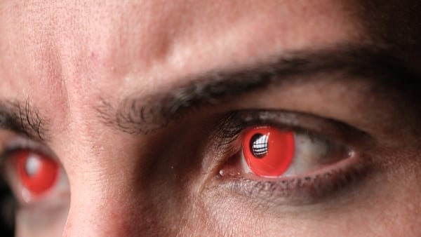 Macro shot focusing on a person's eyes with red contact lenses s
