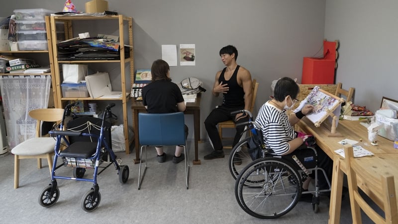 Takuya Usui chats to a woman at the care home he works at