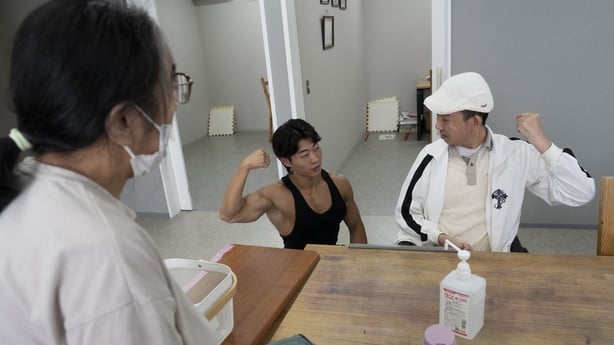 care worker and bodybuilder Hokuto Tatsumi chats with a man at a care home