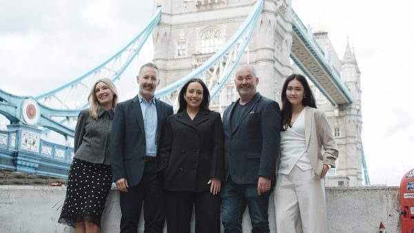 Group of business people pose for a photo in front of London Bridge