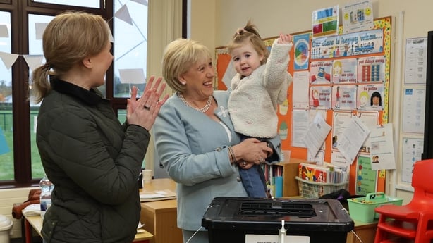 Fine Gael candidate Heather Humphreys casts her vote for the election for the next Irish president with the help of her one-year-old granddaughter Charlotte and daughter Eva
