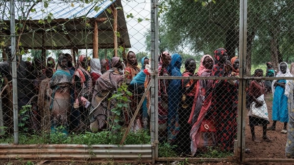 Women line up outside a hybrid distribution site to collect food, cash handouts, and high-energy bars for children in Maban
