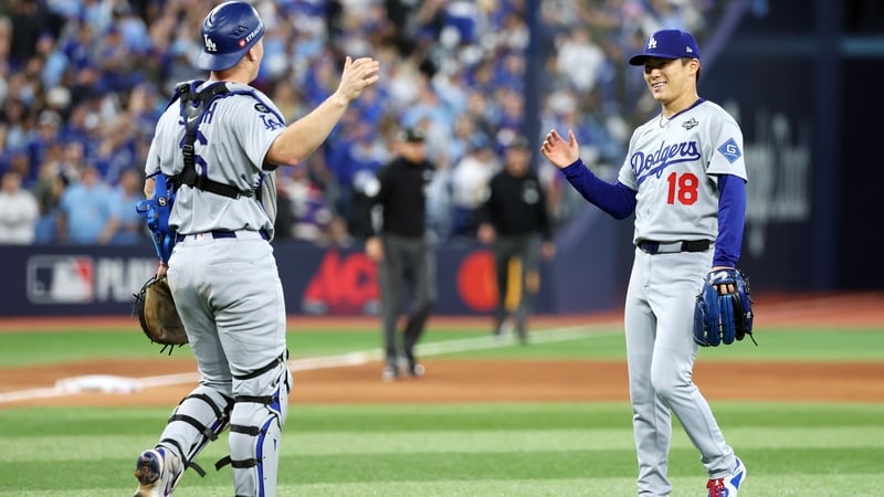 Will Smith (L) and Yoshinobu Yamamoto of the Los Angeles Dodgers celebrate after beating the Blue Jays