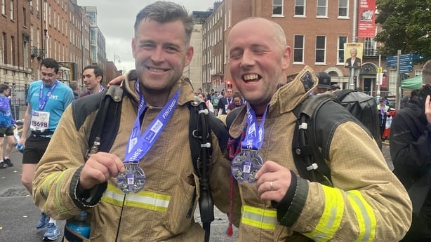Stephen Gallagher and Sean Kane hold their medals after completing the marathon