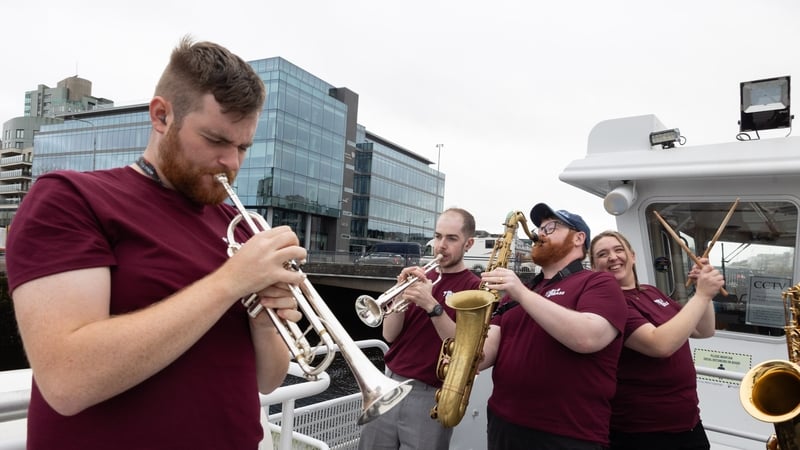A brass band performs in the harbour at the launch of the festival