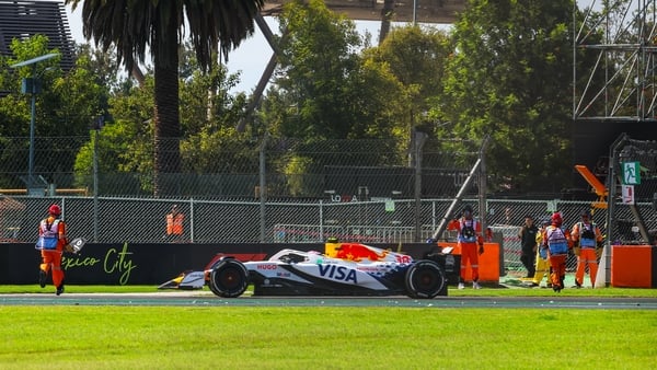MEXICO CITY, MEXICO - OCTOBER 26: Liam Lawson of New Zealand driving the (30) VCARB 02 on track as a Marshall gathers debris during the F1 Grand Prix of Mexico at Autodromo Hermanos Rodriguez on October 26, 2025 in Mexico City, Mexico. (Photo by Kym Illma