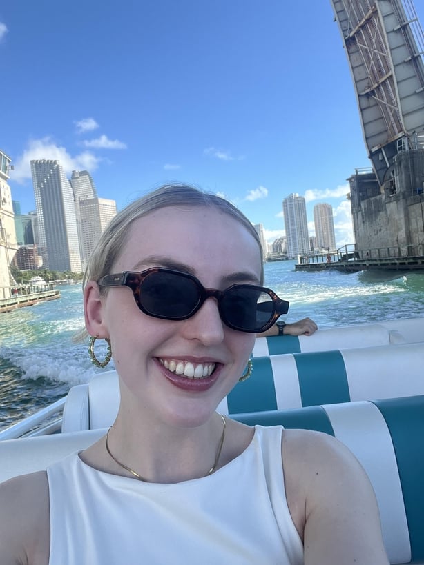 A blonde woman smilling while taking a selfie on a speedboat tour of Miami