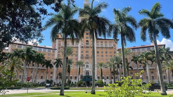 A large building with pine trees in front of it