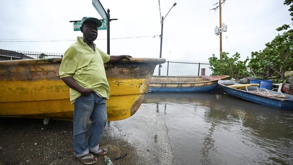 A resident stands at a flooded section of Port Royal in Kingston on October 27, 2025. Hurricane Melissa threatened Jamaica with potentially deadly rains after rapidly intensifying into a top-level Category 5 storm, as residents scrambled for shelter from