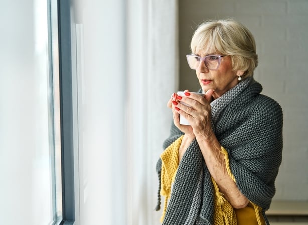 Portrait of a senior elderly woman havin a flu or virus, being sick and drinking a hot drink tea