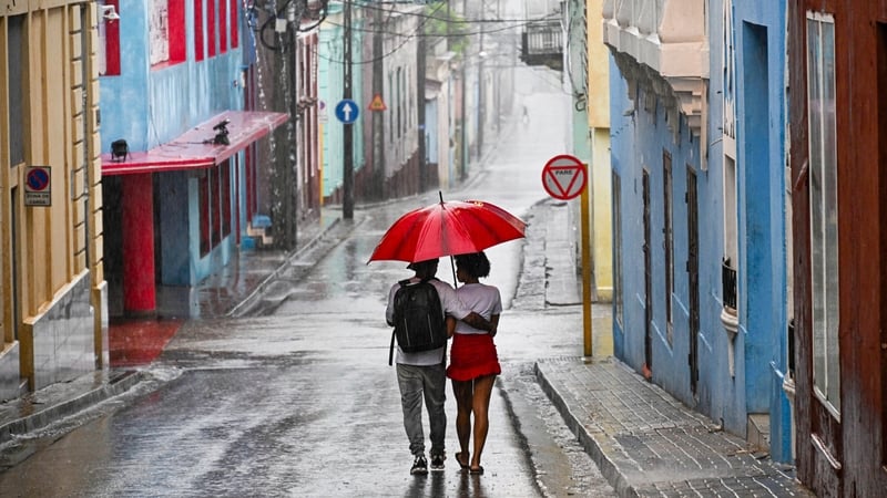 A couple walks in a street before Hurricane Melissa hits the city of Santiago de Cuba, Cuba