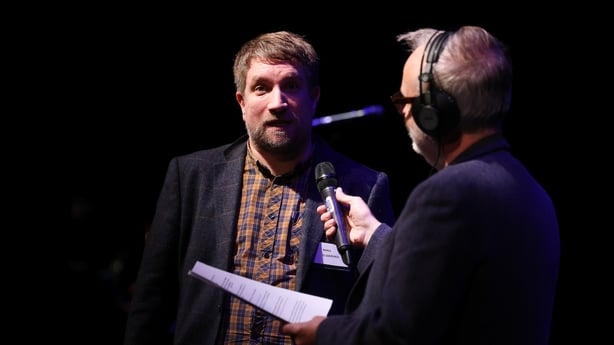 writer Niall O Siadhail discussing his story with Arena presenter Rick O'Shea, on stage at 2025 RTÉ Short Story Competition awards night, Pavilion Theatre, Dun Laoghaire