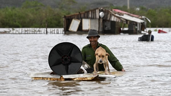 A farmer rescues his dog in Cuba after flooding brought by the hurricane