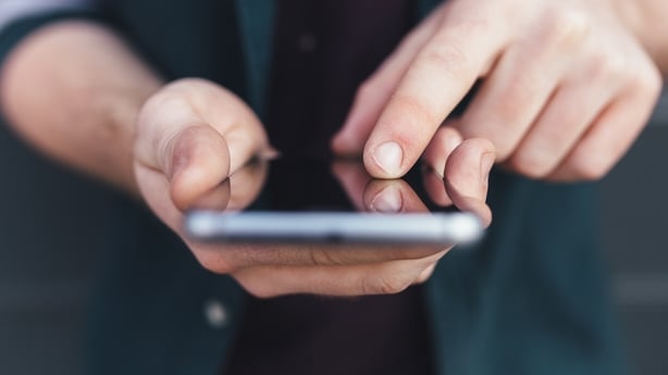 Close up image of a person's hands holding a mobile phone