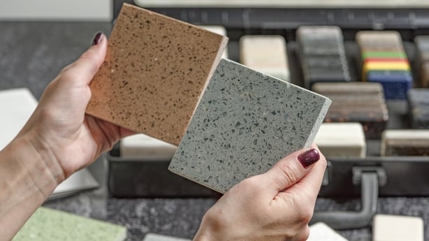 Female hands hold samples of tiles of different colors.
