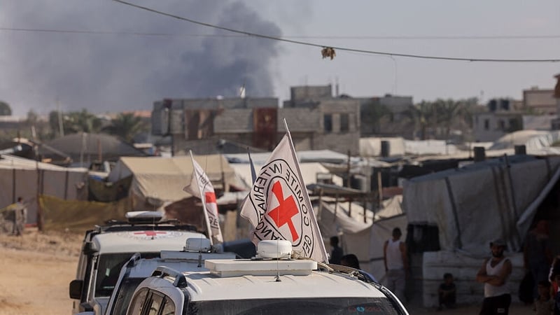 Smoke rises in the background as vehicles of the International Committee of the Red Cross (ICRC) drive through Khan Yunis in Gaza last week