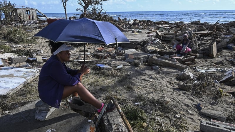 Residents rest amid debris of a damaged house after the passage of Hurricane Melissa in Boca de Dos Rios village, Santiago de Cuba