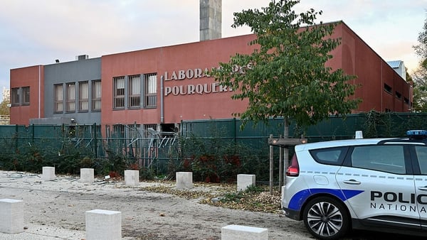 Police car parked at the front of the POURQUERY Laboratories during forensic investigations