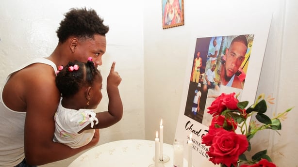 Messiah Burnley, nephew of Chad Joseph, who family members believe was killed in a U.S. military strike on a boat in the Caribbean, carries a girl in front of an altar for Joseph in the family home in Las Cuevas, Trinidad and Tobago, October 22, 2025. REUTERS/Andrea de Silva