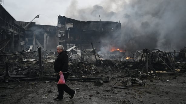 A man walks past the site of a food warehouse hit by Russian missile strike in Kyiv early October