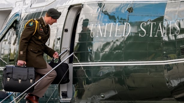 A military aide carries the "nuclear football," which contains launch codes for nuclear weapons as he boards Marine One