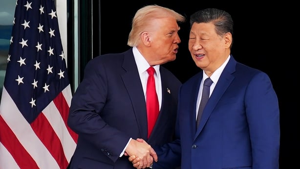 Donald Trump speaks to Chinese President Xi Jinping as they shake hands