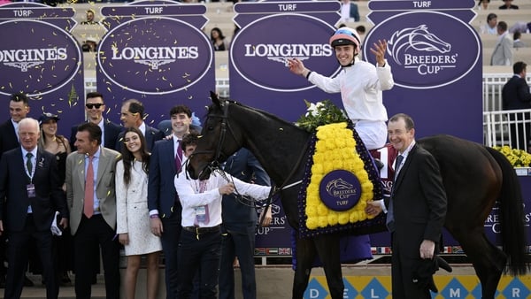 Dylan McMonagle poses for photos after winning the Breeders' Cup Turf race aboard Willie Mullins' Ethical Diamond