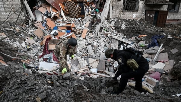 two men work through rubble of a destroyed building in ukraine
