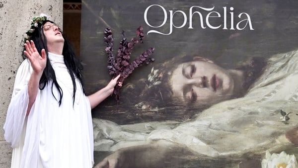 A fan of US singer-songwriter Taylor Swift poses next to a banner with the title 'Home of Taylor Swift's Ophelia'