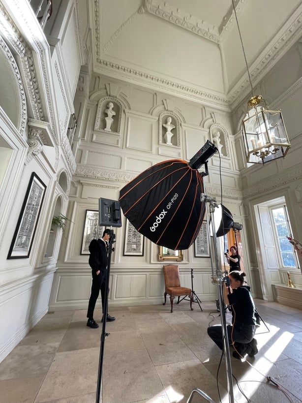 A behind the scenes photo of a photoshoot in an ornate manor house